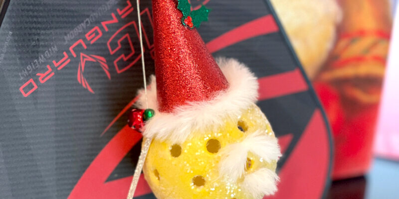 santa pickleball ornament on a pickleball paddle